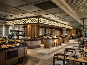 DoubleTree by Hilton Surabaya في سورابايا: لوبي فندق فيه طاولات وكراسي