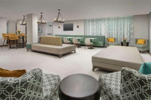uma sala de espera com sofás e uma mesa e cadeiras em Hilton Garden Inn Miami Brickell South em Miami