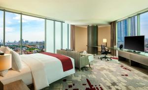 a hotel room with a bed and a desk with a monitor at DoubleTree by Hilton Surabaya in Surabaya