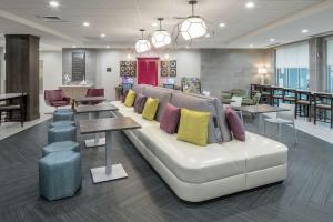 a living room with a couch with pillows on it at Home2 Suites By Hilton Orlando Airport in Orlando