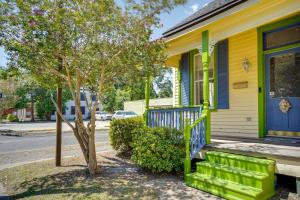 una casa amarilla con un porche verde y un árbol en Opelousas Vacation Rental Near Shopping and Dining!, en Opelousas