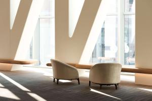 a room with two chairs and large windows at Conrad Washington DC in Washington, D.C.