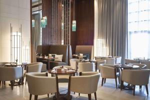 un comedor con mesas y sillas en un restaurante en Hilton Dubai Al Habtoor City, en Dubái