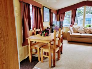a dining room table and chairs in a living room at Lyons Robin Hood Holiday Park, The Shamrock Way in Meliden