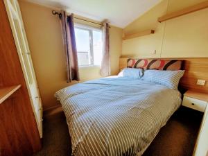 Dormitorio pequeño con cama y ventana en Lyons Robin Hood Holiday Park, The Shamrock Way, en Meliden