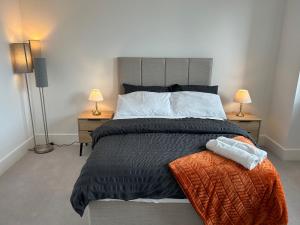 Luxurious two-bedroom flat with scenic views في لندن: غرفة نوم بسرير كبير فيها مصباحين