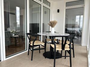 uma mesa de jantar com cadeiras e um vaso sobre ela em Luxurious two-bedroom flat with scenic views em Londres