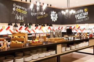 a restaurant with a counter with plates and food at Hampton By Hilton Berlin City East Side Gallery in Berlin +20 photos