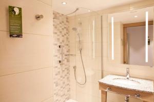 a bathroom with a shower and a sink at Hampton By Hilton Berlin City East Side Gallery in Berlin