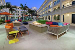 eine Terrasse mit Gartenmöbeln und eine Feuerstelle vor einem Gebäude in der Unterkunft Homewood Suites By Hilton San Diego Central in San Diego