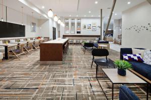 a lobby with tables and chairs and a large screen at Homewood Suites By Hilton San Diego Central in San Diego