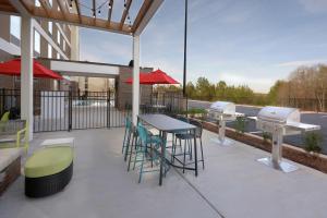 a patio with a table and chairs and a grill at Home2 Suites By Hilton Duncan in Duncan