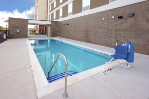 uma piscina com uma cadeira azul ao lado de um edifício em Home2 Suites By Hilton Duncan em Duncan