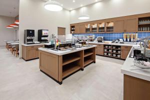 a large kitchen with wooden cabinets and counters at Homewood Suites By Hilton San Diego Central in San Diego