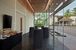 a lobby with black tables and glass walls at DoubleTree by Hilton Phuket Banthai Resort in Patong Beach