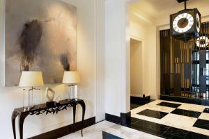 a hallway with a clock and a table with lamps at Waldorf Astoria Atlanta Buckhead in Atlanta