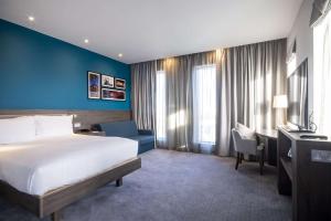 a hotel room with a bed and a blue wall at Hampton By Hilton Stockton On Tees in Stockton-on-Tees