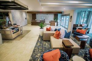 a living room with couches and tables in a building at Hilton Garden Inn West Palm Beach I95 Outlets in West Palm Beach