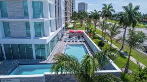 uma vista aérea de um hotel com piscina e palmeiras em Hilton Garden Inn West Palm Beach I95 Outlets em West Palm Beach