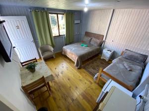 vistas a una habitación con cama y sofá en Cabana Pé Da Serra dos Bitus, en Urubici
