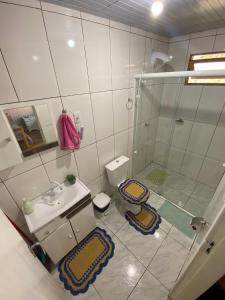 y baño con ducha, lavabo y aseo. en Cabana Pé Da Serra dos Bitus, en Urubici