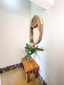 einen Tisch mit einer Vase mit einer Pflanze darauf in der Unterkunft Tayrona Cachaco River Ecohostal in El Zaino