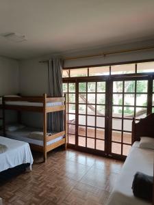 a bedroom with two bunk beds and a balcony at Pousada Falls Park in Foz do Iguaçu