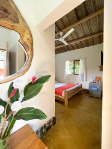 a room with a bed and a mirror at Tayrona Cachaco River Ecohostal in El Zaino
