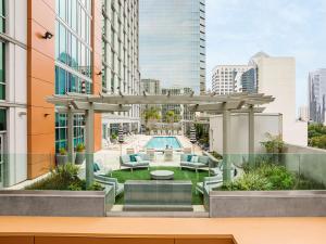 an outdoor patio with a pergola and a pool at Carte Hotel San Diego Downtown, Curio Collection By Hilton in San Diego