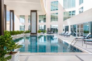 een zwembad in het midden van een gebouw bij Doubletree By Hilton Doha - Al Sadd in Doha