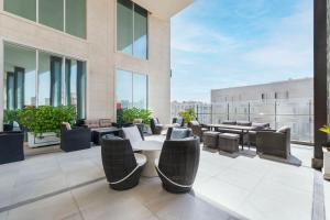 un patio con mesas y sillas en un edificio en Doubletree By Hilton Doha - Al Sadd, en Doha