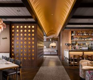 a restaurant with a gold ceiling and a bar at C. Baldwin, Curio Collection by Hilton in Houston