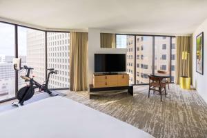 a hotel room with a bed and a flat screen tv at C. Baldwin, Curio Collection by Hilton in Houston