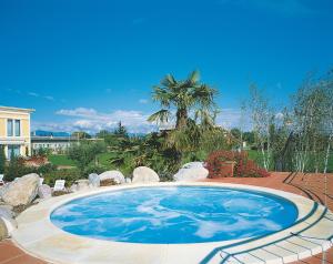 a large swimming pool in a yard with a house at Hotel Touring in Coccaglio