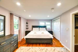 a bedroom with a bed and a dresser and windows at Waltham Vacation Rental about 12 Mi to Downtown Boston in Waltham