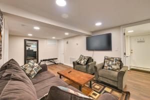 a living room with couches and a flat screen tv at Waltham Vacation Rental about 12 Mi to Downtown Boston in Waltham