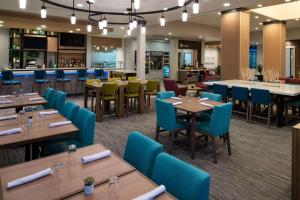 uma sala de jantar com mesas e cadeiras azuis em Hilton Garden Inn Seattle Lynnwood, Wa em Lynnwood