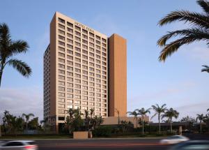 een hoog gebouw met palmbomen ervoor bij Hotel Fera Anaheim, a DoubleTree by Hilton Hotel in Anaheim