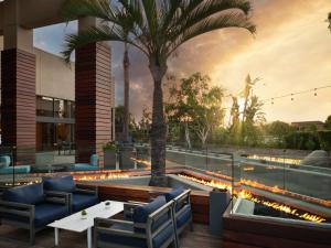 een restaurant met een zwembad en palmbomen en verlichting bij Hotel Fera Anaheim, a DoubleTree by Hilton Hotel in Anaheim