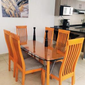 mesa de madera con 4 sillas y cocina en Comodidad y Tranquilidad a tu Alcance en San Juan del Río