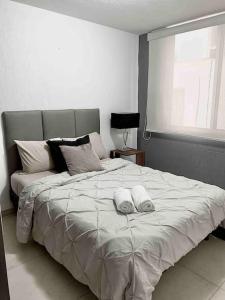 een slaapkamer met een groot bed en 2 handdoeken bij Comodidad y Tranquilidad a tu Alcance in San Juan del Río