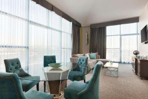 a living room with a glass table and chairs at Embassy Suites by Hilton Brea - North Orange County in Brea