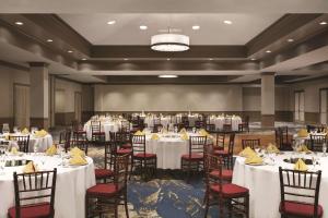 um salão de banquetes com mesas e cadeiras brancas em Embassy Suites by Hilton Brea - North Orange County em Brea