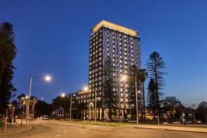 Doubletree By Hilton Perth Waterfront في بيرث: مبنى طويل على شارع المدينة في الليل