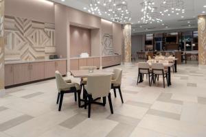 a restaurant with tables and chairs in a lobby at Hilton Garden Inn Ocala Downtown, Fl in Ocala