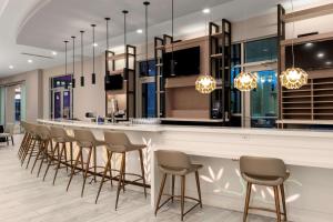 a bar with a row of stools in a room at Hilton Garden Inn Ocala Downtown, Fl in Ocala