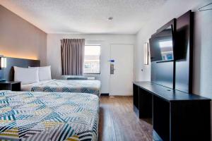 una camera d'albergo con due letti e una televisione di Motel 6-Salem, OR a Salem