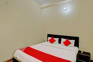 a bedroom with a bed with red pillows on it at Super OYO Flagship Sunrise Inn in Lucknow