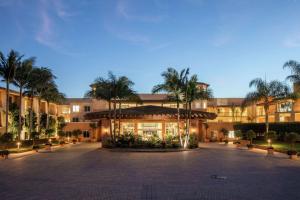 a large building with palm trees in front of it at The Cassara Carlsbad, Tapestry Collection By Hilton in Carlsbad