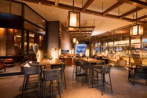 un ristorante con tavoli e sedie e un bar di Conrad Centennial Singapore a Singapore